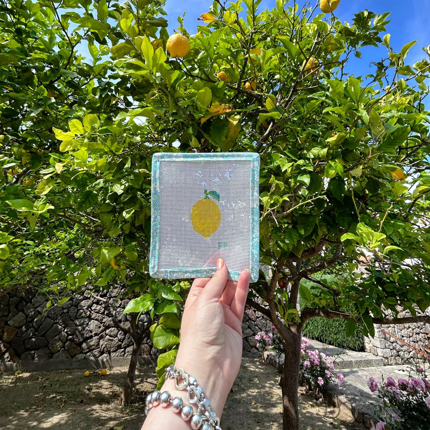 Mini lemon needlepoint canvas showing a bright yellow lemon with a green leaf, hand-painted on white 13 mesh.