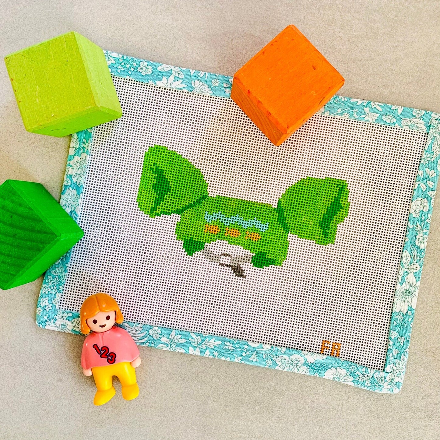 Pool floatie needlepoint canvas featuring a bright green inflatable float , hand-painted on white 18 mesh.
