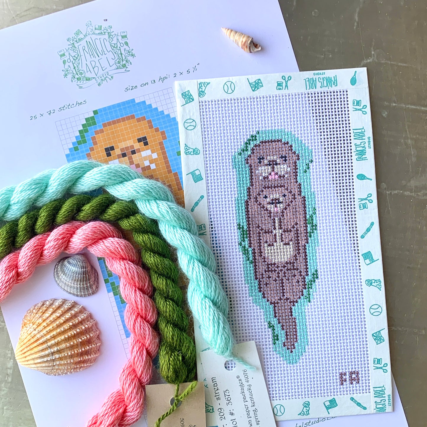 Otter needlepoint canvas kit—brown otter floating on aqua water, 2 × 5.5″ on 13-mesh, DIY coastal décor project