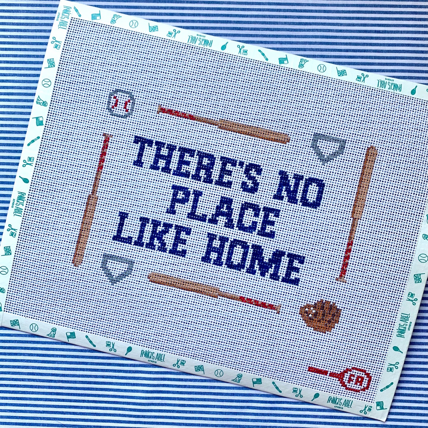 ‘There’s No Place Like Home’ pillow needlepoint canvas—navy text bordered by baseball bats, glove, ball & home plate, 8.75 × 6.5″ on 13-mesh DIY project