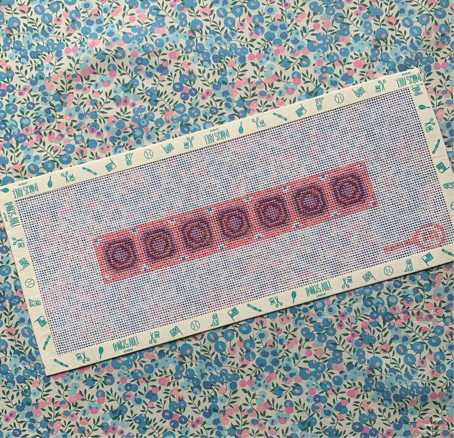 Union Station key-fob needlepoint canvas kit in pink—ceiling-inspired geometric pattern in rose, olive, and teal, 8¾ × 1½″ on 14-mesh DIY accessory