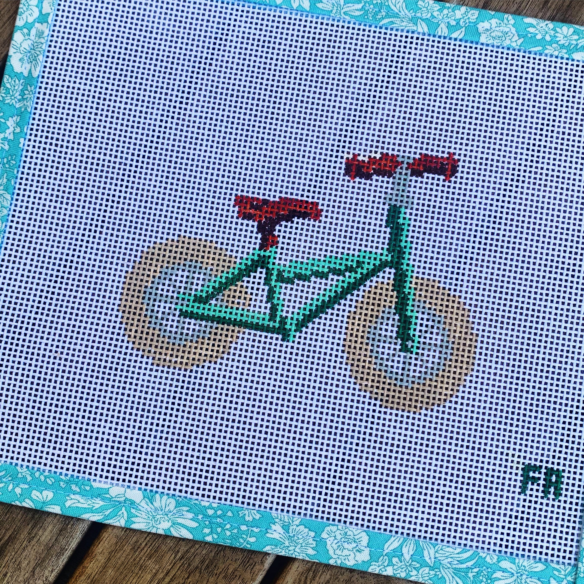 Green balance bike needlepoint chart—printed PDF grid showing a toddler’s balance bike silhouette outlined in Green on natural 14-mesh canvas layout