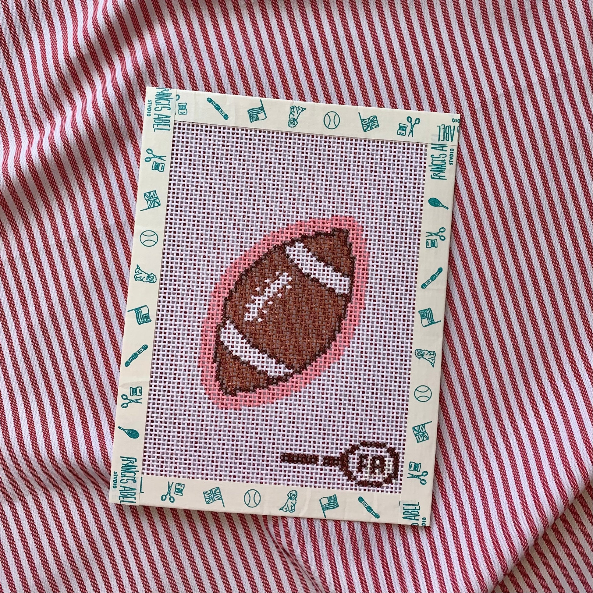 Mini footballneedlepoint canvas—small football on pink background natural 13-mesh canvas, 3⅛ × 2¼″ DIY whimsical décor project
