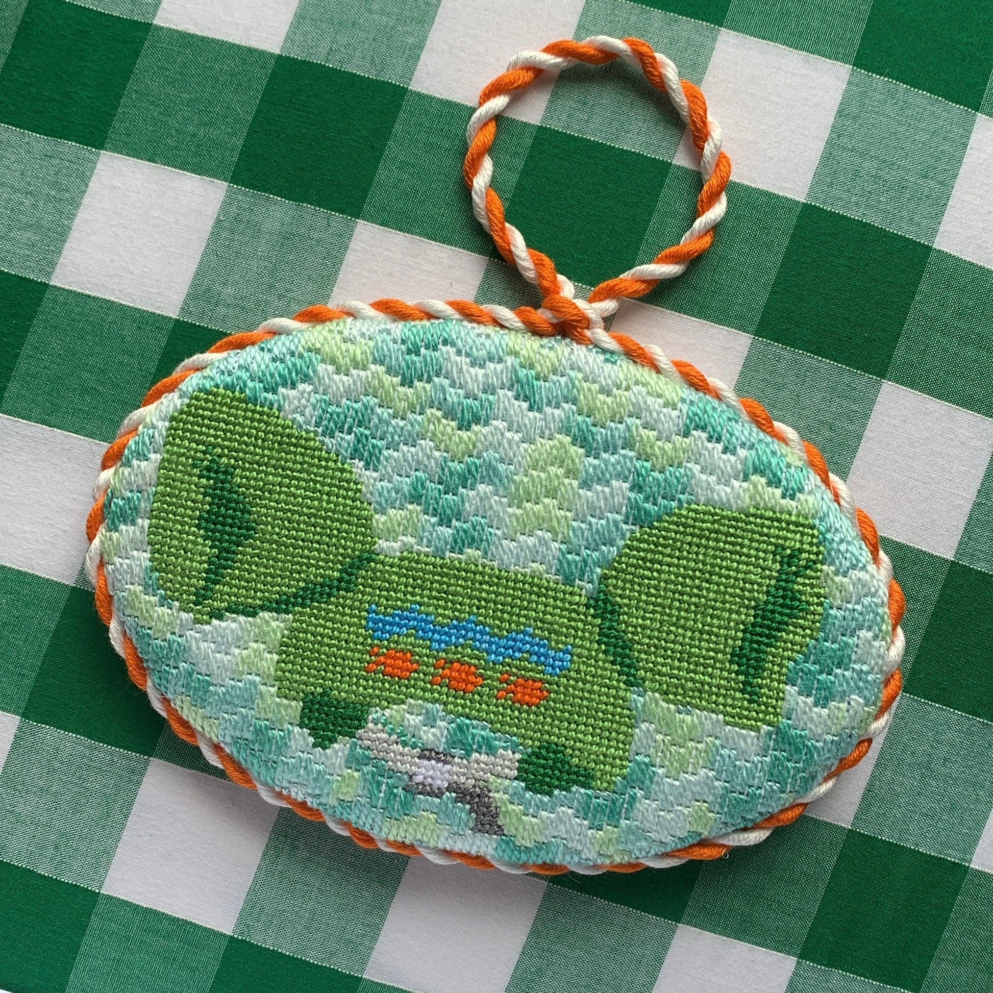 Pool floatie needlepoint canvas featuring a bright green inflatable float , hand-painted on white 18 mesh.