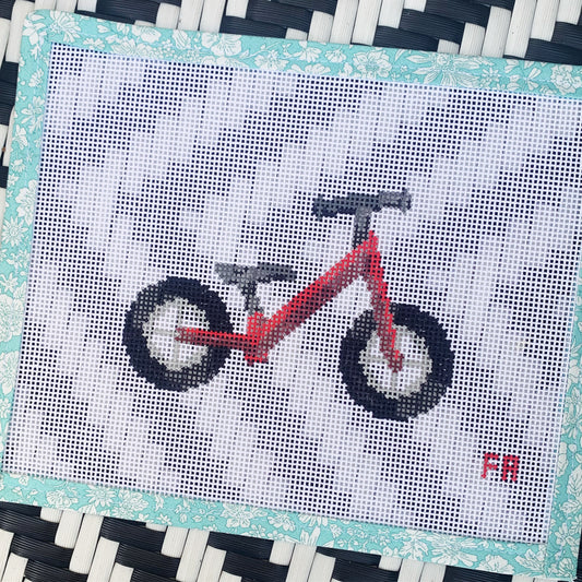 Red balance bike needlepoint canvas kit—stylized red toddler balance bike printed on natural 14-mesh canvas, 3¼ × 5″ DIY nursery décor project
