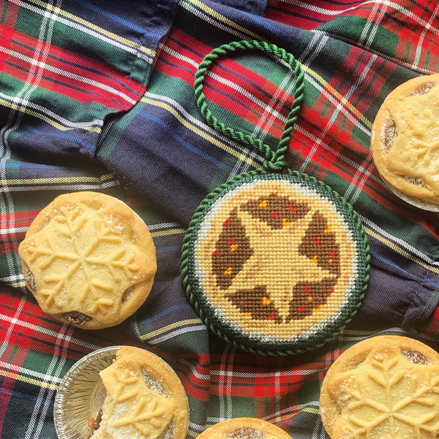 Close-up of mince pie needlepoint canvas—textured golden pastry stitches and star vent on 13-mesh holiday canvas 
