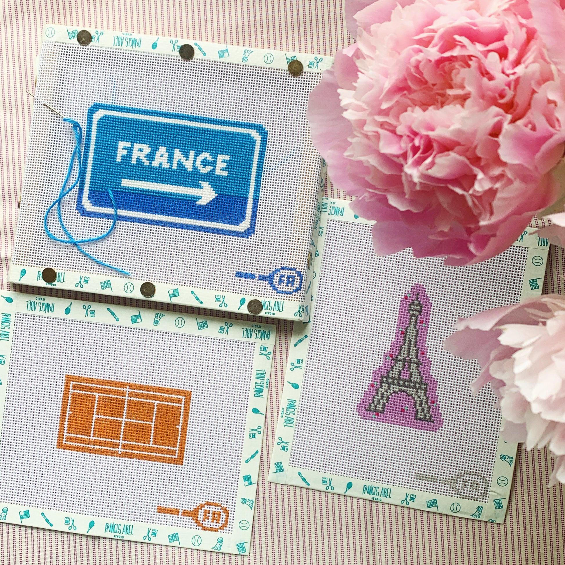 Mini clay tennis court needlepoint canvas kit—3⅛ × 2″ orange clay court with white boundary lines printed on natural 14-mesh canvas for DIY patch or scissors fob
