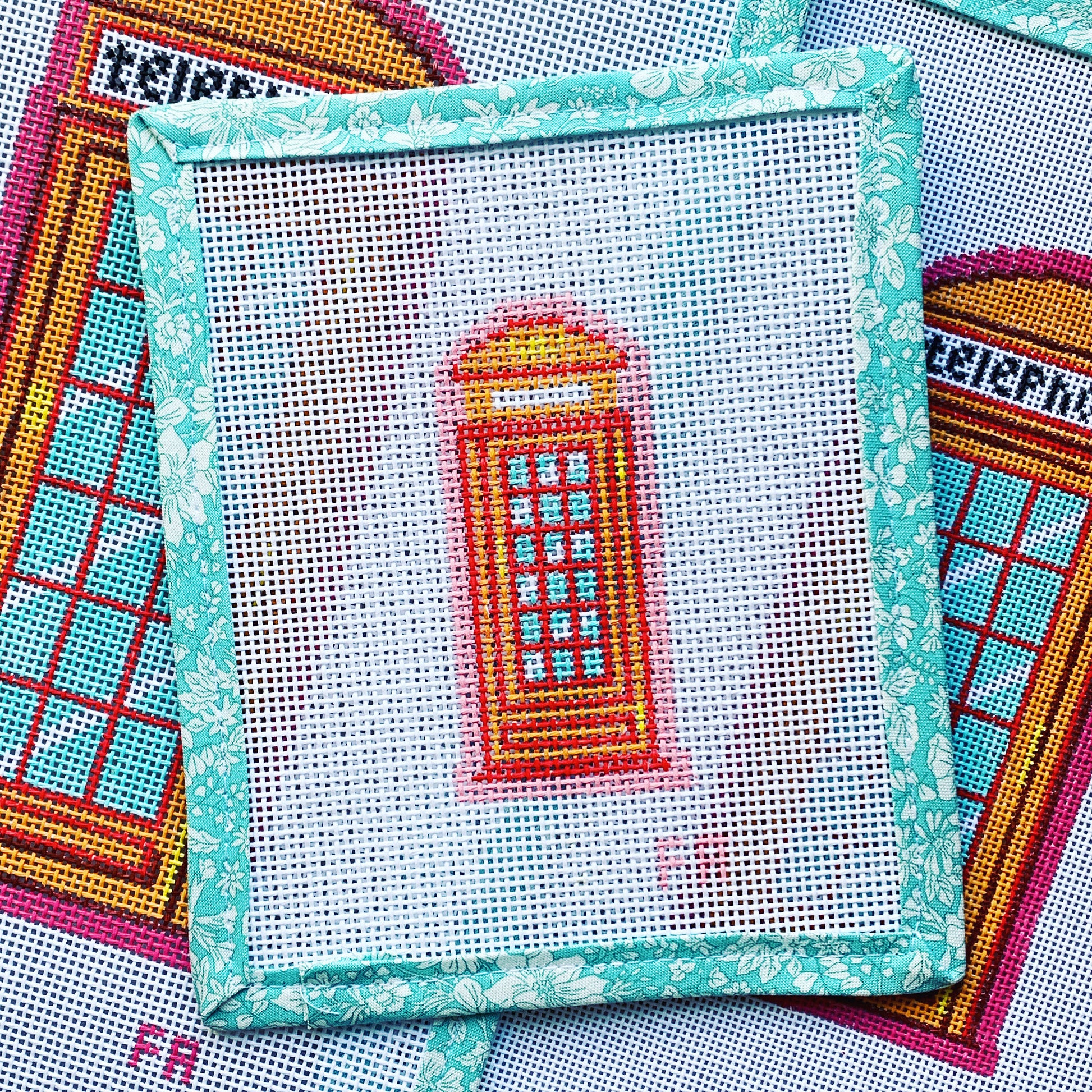 Mini London telephone booth needlepoint canvas featuring a classic red British phone box with pastel details on white 13 mesh.