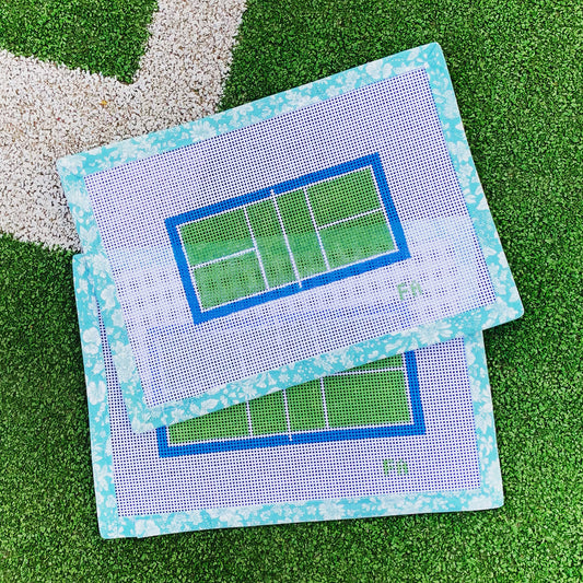 Pickleball court needlepoint canvas ornament with a bright blue and green court, pink border, and white net detail on 18 mesh.