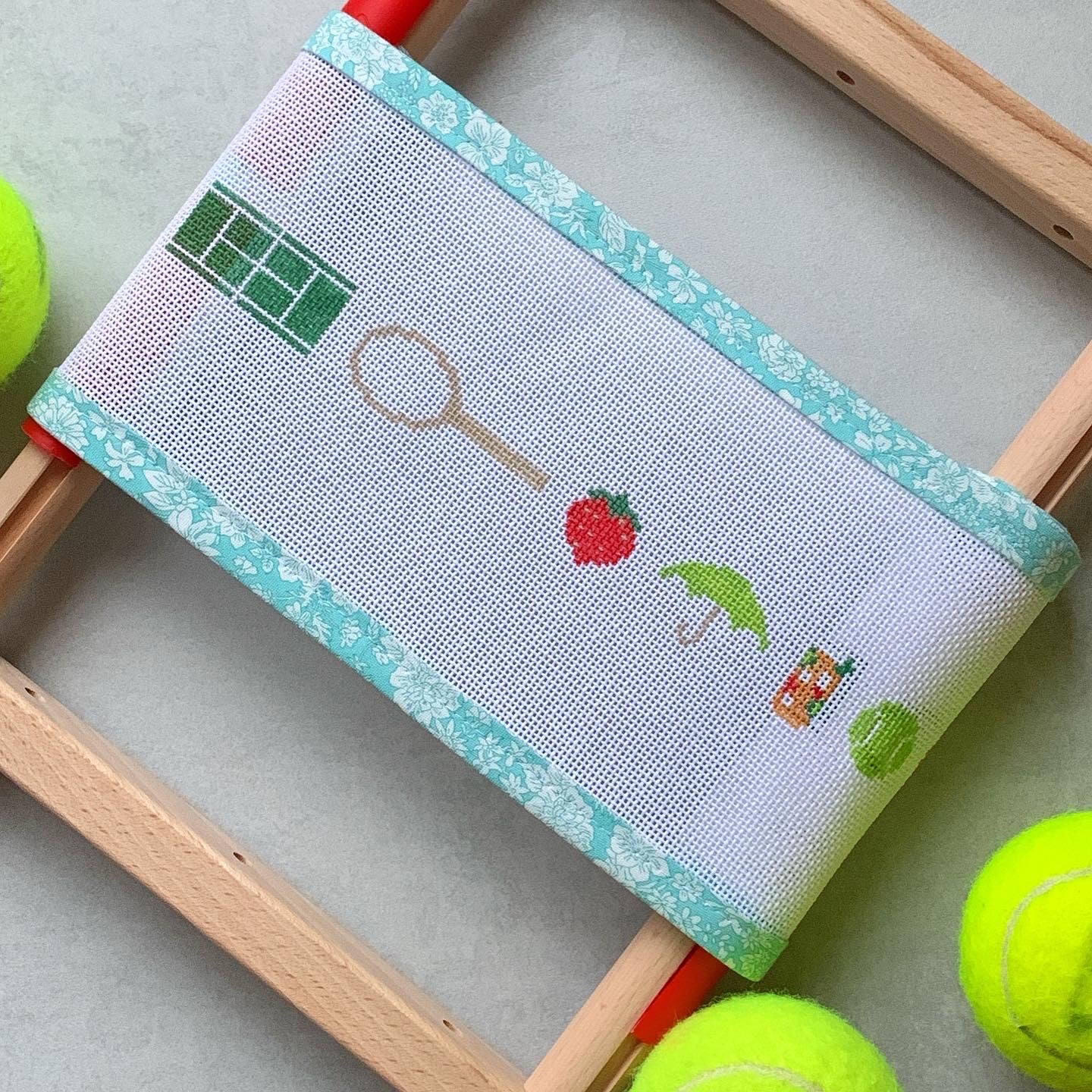 Long strip of Tennis Icons belt/hat band/bag strap needlepoint canvas—repeating motifs of tennis racket, ball, sneaker, water bottle, trophy, and drink on natural 18-mesh, 38″ × 1″ DIY accessory kit